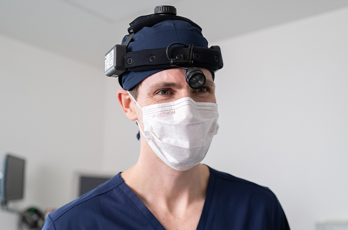 Priv.-Doz. Dr. med. Daniel Häussler mit Mundschutz und OP-Haube. 