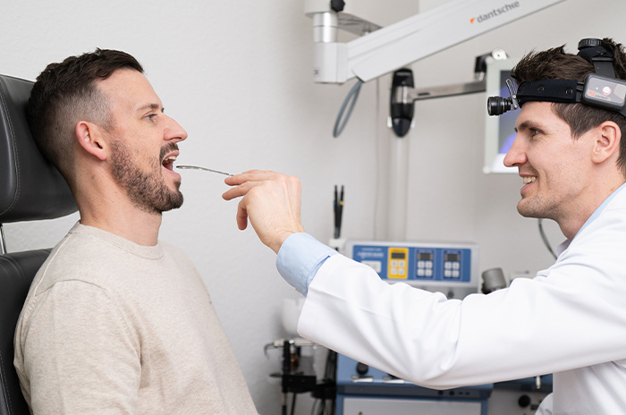 Priv.-Doz. Dr. med. Daniel Häussler untersucht den Mundraum eines Pateinten in der HNO-Praxis in Bruchsal.